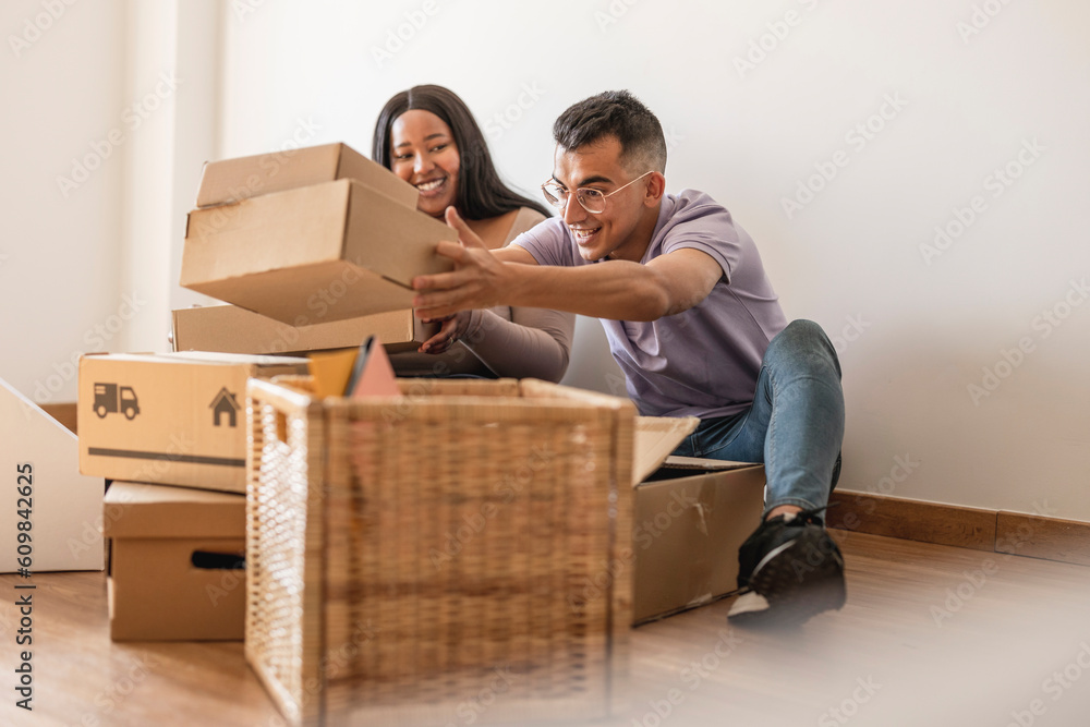 Couple unpacking cardboard boxes in new home Couple unpacking cardboard boxes in new home