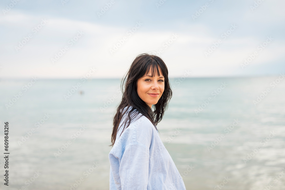 Smiling woman in front of sea at beach Smiling woman in front of sea at beach