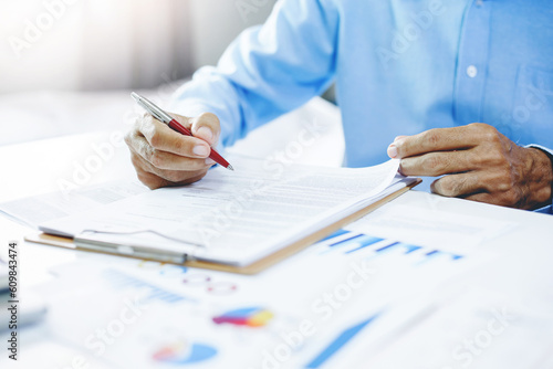 Asian businessman working with documents report at office, financial chart analysis and planning for business growth and sucess in the future