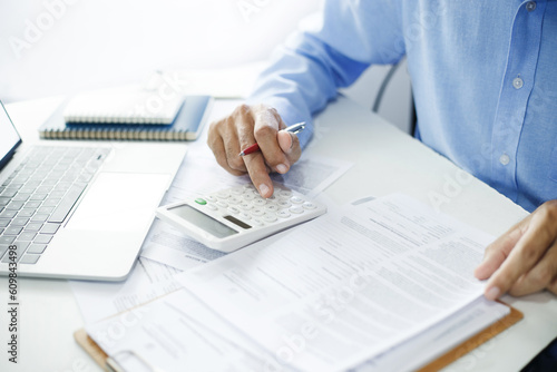 Asian businessman read write doing report document, professional accountant calculating annual balance cash flow money report finance at office