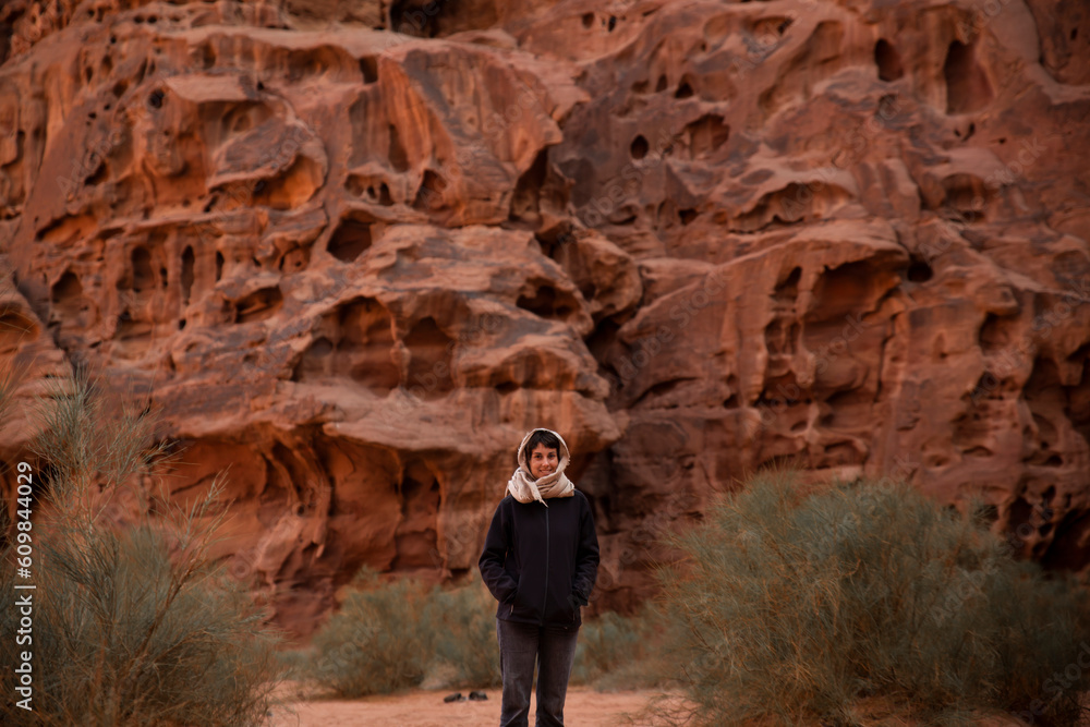 Smiling young woman standing in front of rock wall Smiling young woman standing in front of rock wall