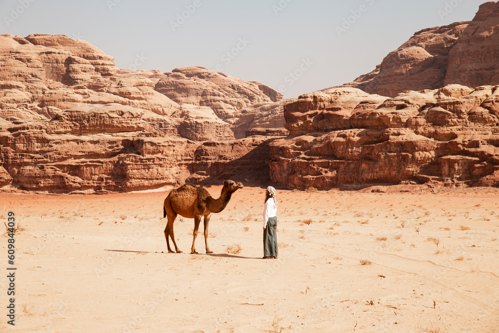 Young woman standing in front of camel on sunny day Young woman standing in front of camel on sunny day