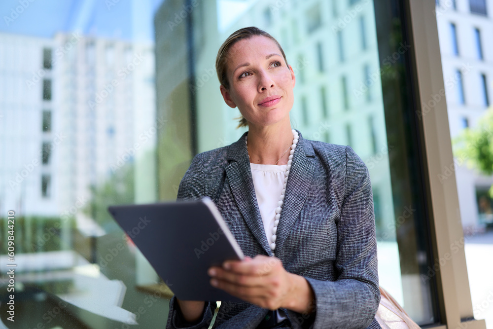 Thoughtful businesswoman holding tablet PC Thoughtful businesswoman holding tablet PC