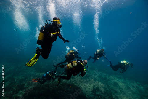 Friends scuba diving together in sea photo