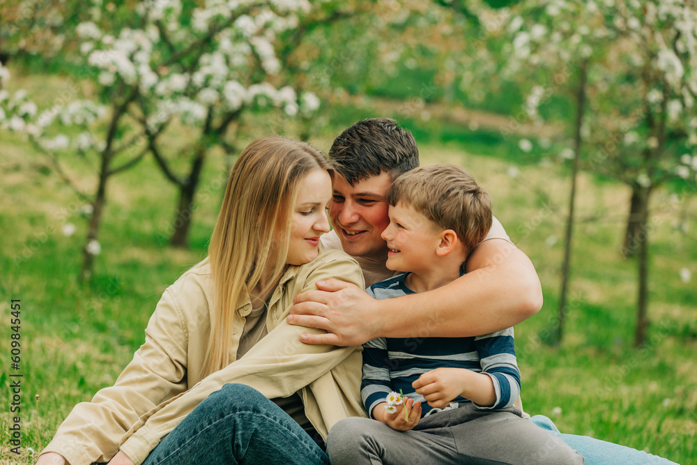 Smiling father and mother with son embracing each other in garden Smiling father and mother with son embracing each other in garden