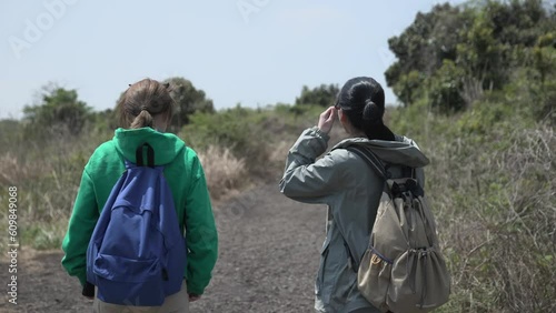 친구와 함께 제주도 오름을 걸으며 산책하는 모습 