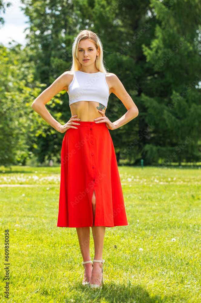 Portrait of a young beautiful blonde woman in a long red skirt Portrait of a young beautiful blonde woman in a long red skirt
