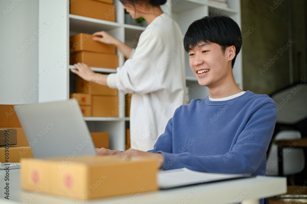 A male online shop owner is checking orders on the website on his laptop A male online shop owner is checking orders on the website on his laptop