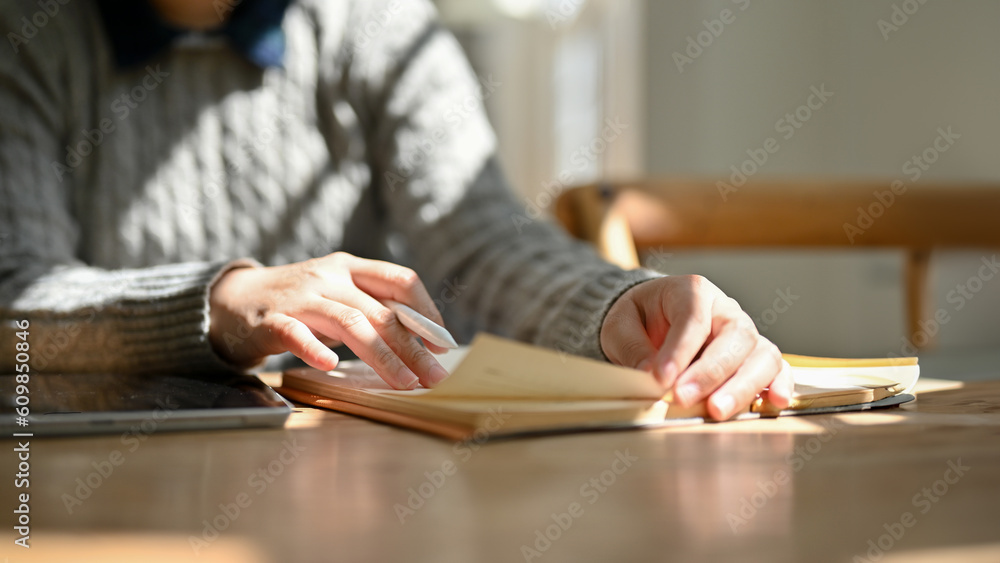 Close-up image of a female college student is reading a book in the cozy library