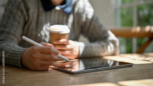 A female using her digital tablet to manage her work while sitting in the coffee shop.