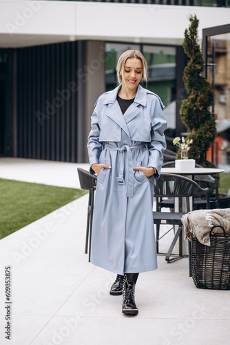 Young woman in blue coat walking in the city
