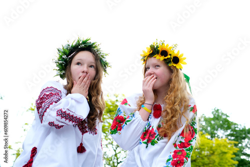 beautiful young teenage girl in wreath for Ukrainian holiday with friend communicate place for advertising text ukrainian tradition put a wreath on her head weave braids embroidered shirts