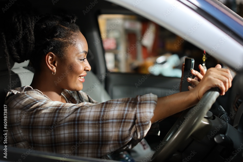 Portrait of happy afirican woman with smiling face driving car vehicle while using smart mobile phone on the road outdoor Portrait of happy afirican woman with smiling face driving car vehicle while using smart mobile phone on the road outdoor