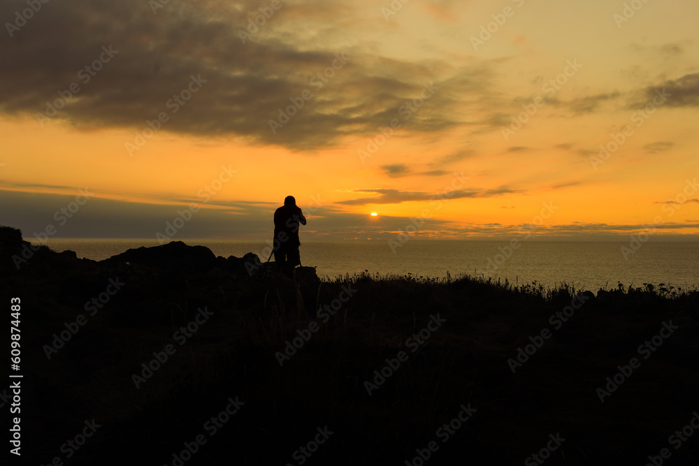 a silhouette photographer taking photo with professional camera in sunrise. photography day