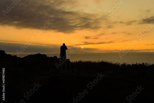 a silhouette photographer taking photo with professional camera in sunrise. photography day