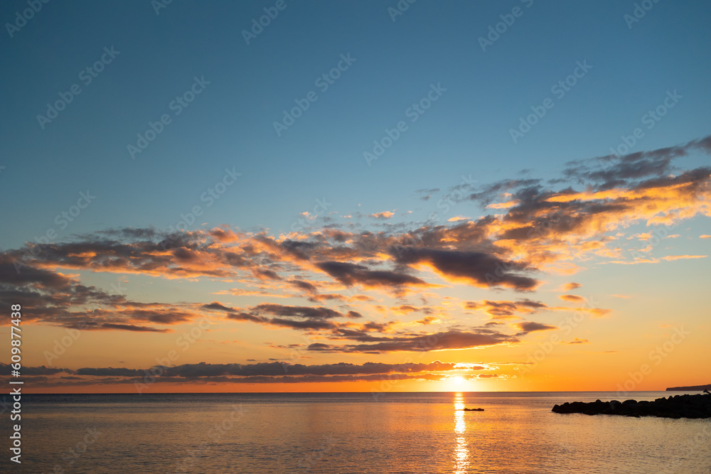 Fototapeta premium Idyllic view of ocean sunset. Reflection of golden sundown on the sea water. Relax seascape with copy space. Concept of summer, travel and calmness