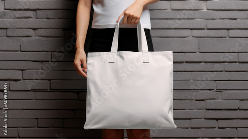 Man is holding bag canvas fabric for mockup blank template isolated on gray background. Generative ai
