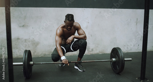 Weightlifting, bodybuilder and black man with barbell in gym for training, exercise and strong workout. Fitness, muscles and male person lifting weights for challenge, wellness and body strength