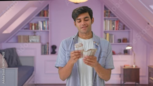 Happy Indian young man counting money