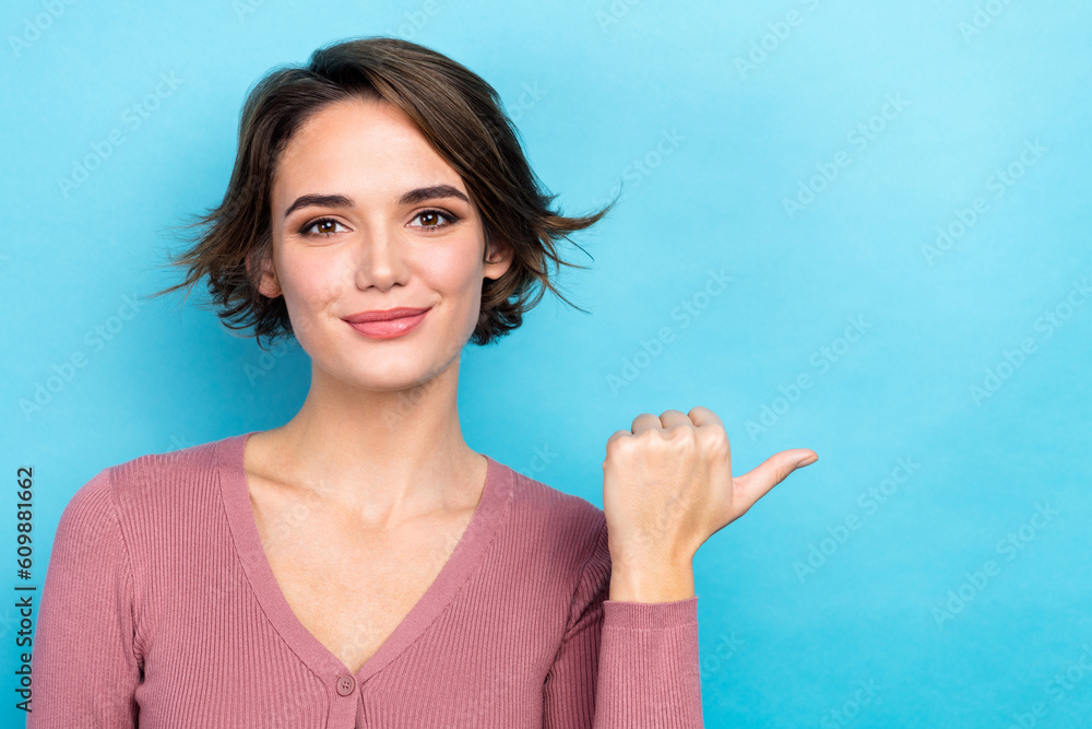 Photo of dreamy adorable woman dressed pink shirt pointing thumb empty space isolated blue color background Photo of dreamy adorable woman dressed pink shirt pointing thumb empty space isolated blue color background