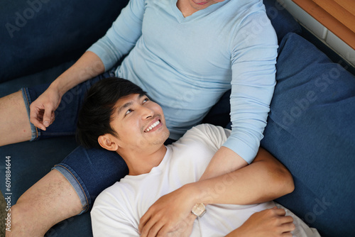 gay men Lie down on boyfriend\'s lap. Happy Gay couple tender moments in livingroom. LGBTQ Homosexual love relationship and gender equality concept. gender diversity