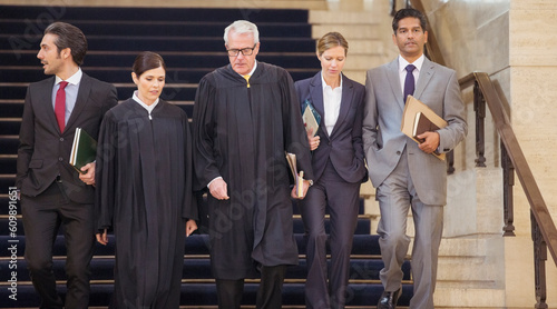 Tableau sur toile Judges and lawyers walking through courthouse together