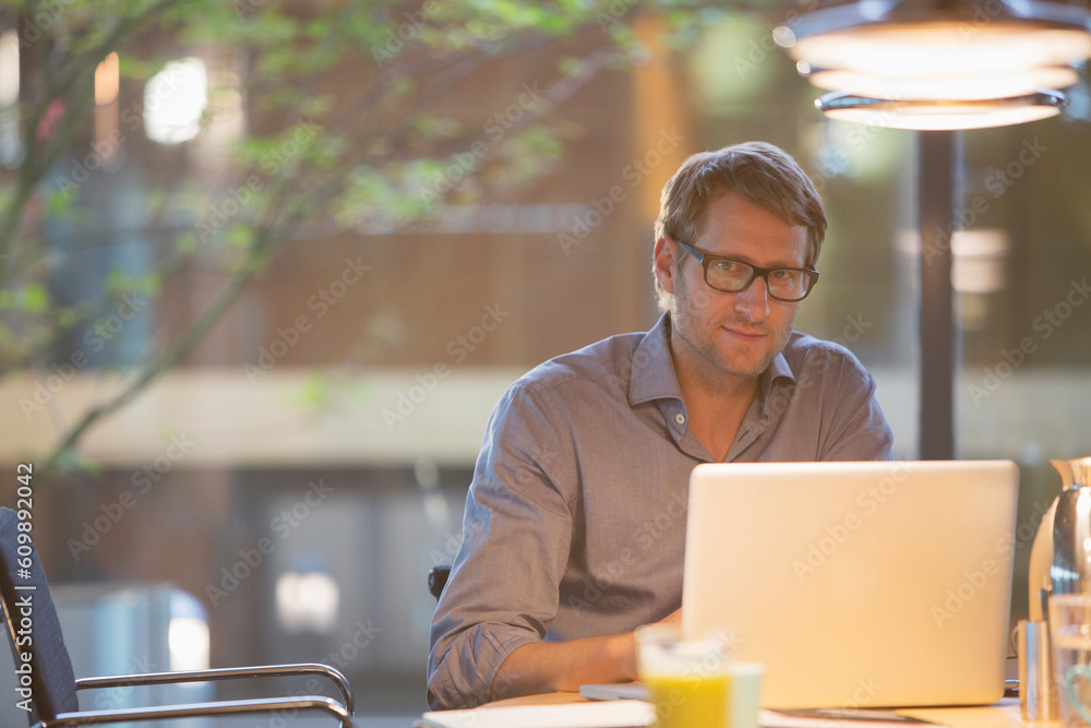 Businessman working at laptop in office Businessman working at laptop in office