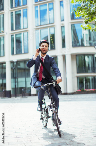 Businessman talking on cell phone on bicycle