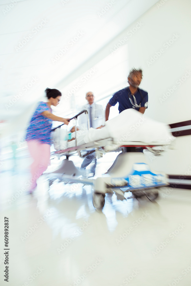 Fototapeta premium Doctors and nurse rushing patient in stretcher in hospital corridor