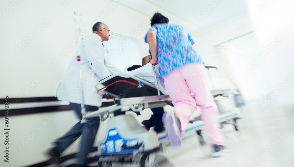 Doctor and nurse rushing patient on stretcher in hospital corridor Doctor and nurse rushing patient on stretcher in hospital corridor