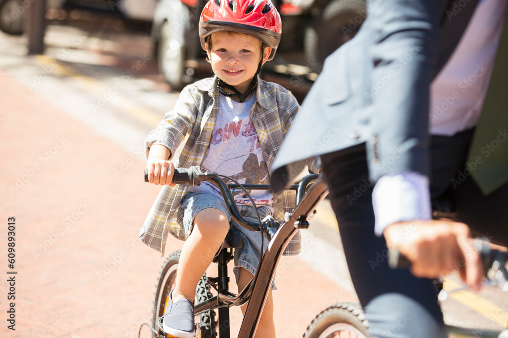 Naklejka premium Portrait smiling boy riding bicycle on sunny road
