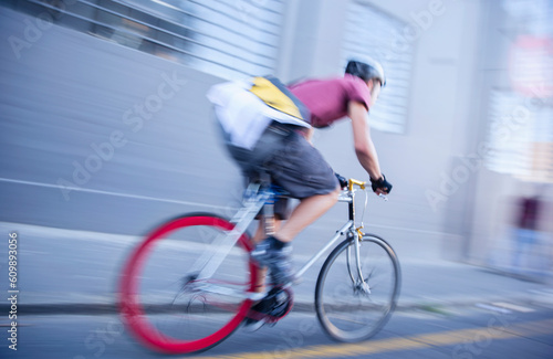 Bicycle messenger speeding down urban street