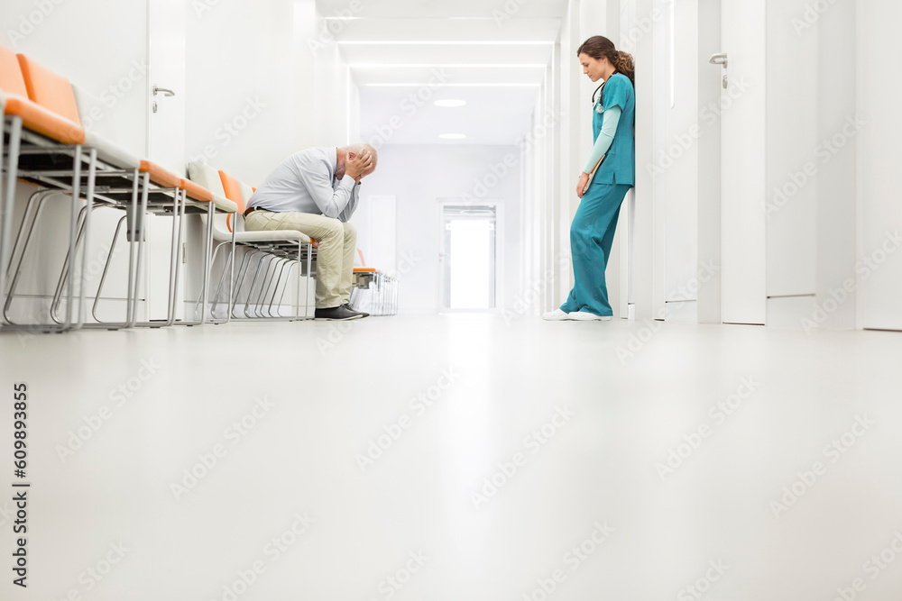 Stressed doctor and nurse in hospital corridor Stressed doctor and nurse in hospital corridor