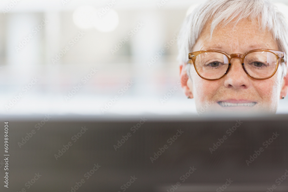 Senior businesswoman with eyeglasses using computer