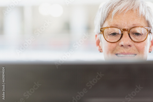 Senior businesswoman with eyeglasses using computer