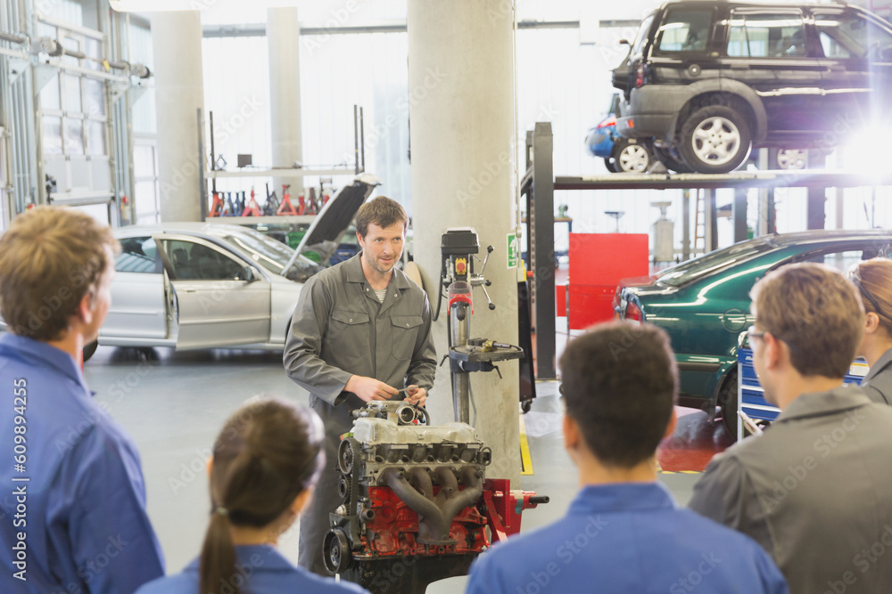 Mechanic explaining car engine to students in auto repair shop Stock ...