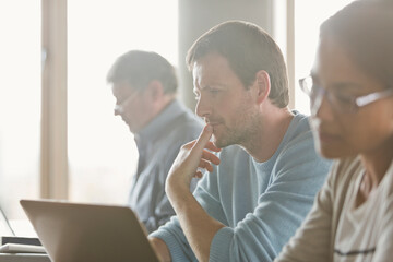 Focused man studying in adult education classroom