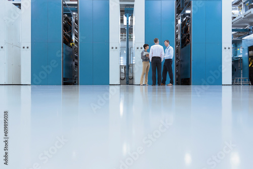 Workers talking in front of machinery in factory