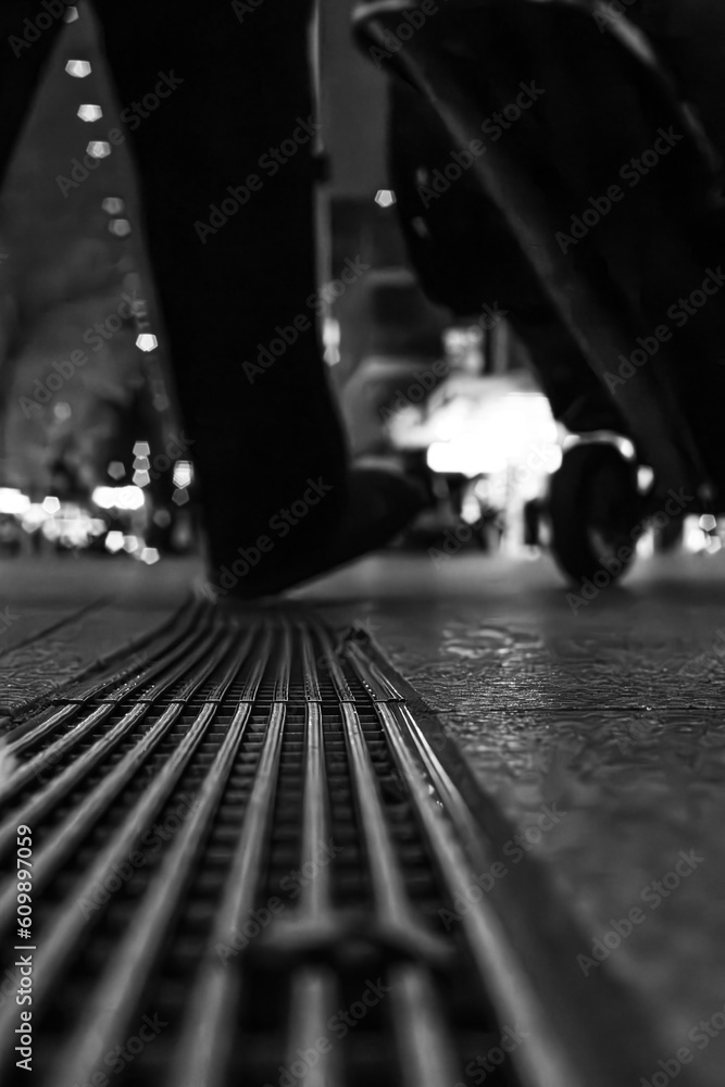 drain in the city with somebody walking over it drain in the city with somebody walking over it