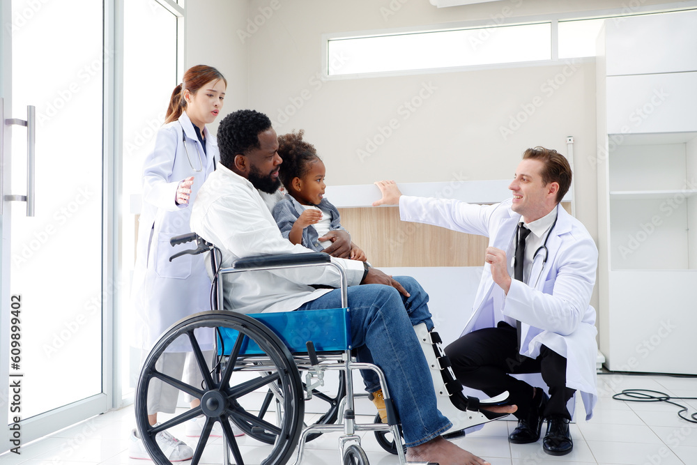 Doctor caring for a patient with a broken leg sitting in a wheelchair. Doctor caring for a patient with a broken leg sitting in a wheelchair.