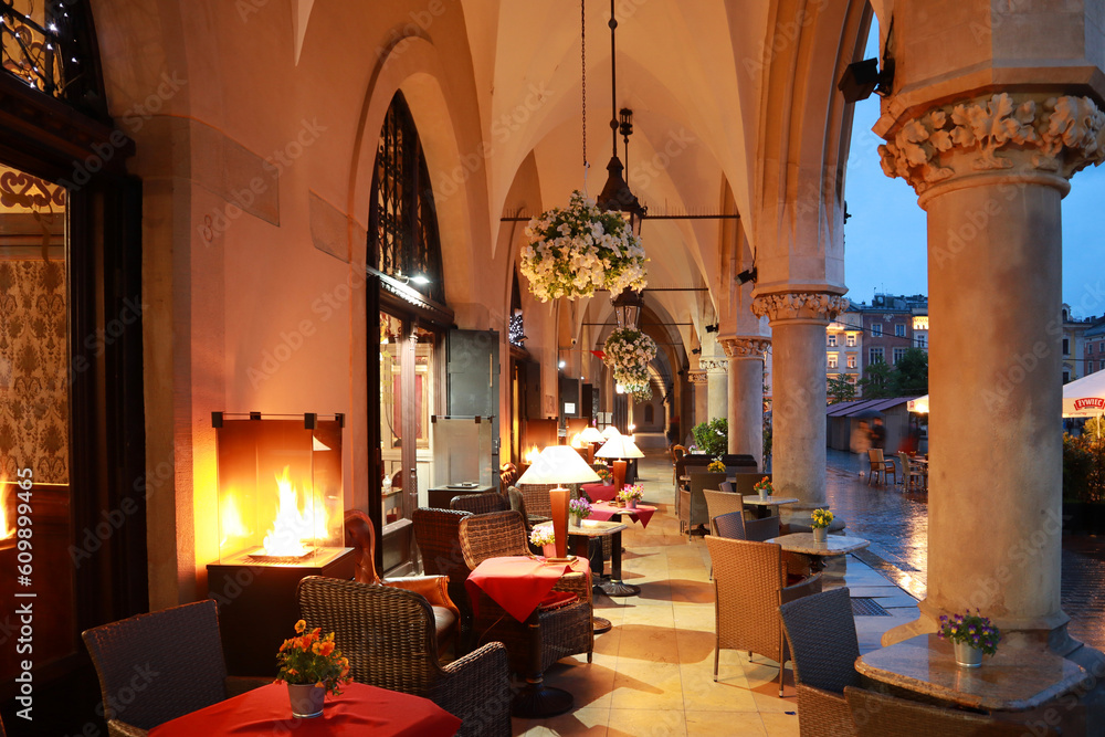 Cafe in Sukiennice - old malls on the Main Market Square (Rynek Glowny) in evening time in Krakow, Poland
