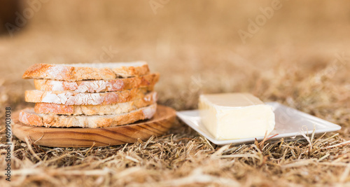 butter and slices of bread in hay photo
