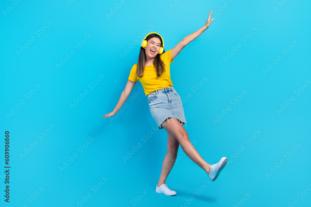 Full length portrait of overjoyed cheerful person dancing enjoy favorite song isolated on blue color background Full length portrait of overjoyed cheerful person dancing enjoy favorite song isolated on blue color background