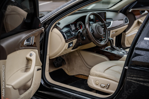 Luxury modern car interior. Steering wheel, shift lever, speedometer, display, gearbox handle, and multimedia dashboard. Detail of car interior inside. Automatic gear stick. © Serhii