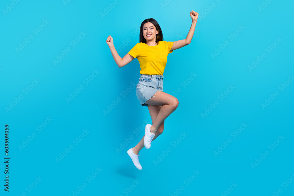 Full length photo of delighted excited person jumping raise fists success isolated on blue color background