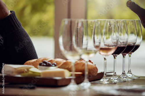 Wine tasting, cheese platter and winery restaurant with alcohol and glass for customer. Waiter, drink and sommelier with bottle for wines and food pairing in a fine dining and luxury experience