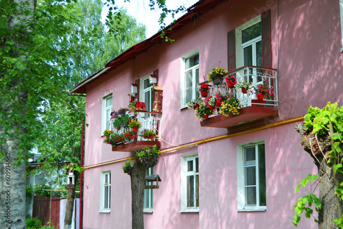 Beautiful Old Pink House decorated with birdhouses and flowers.