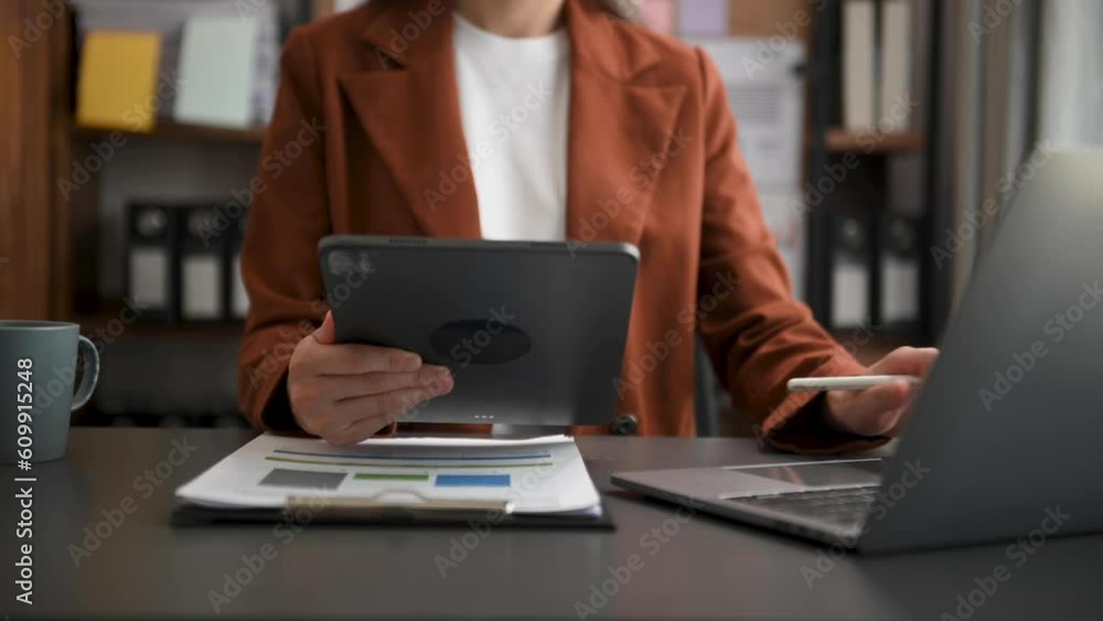 businesswoman hand working with digital tablet computer and smart phone with financial business strategy layer effect on desk in morning light. businesswoman hand working with digital tablet computer and smart phone with financial business strategy layer effect on desk in morning light.