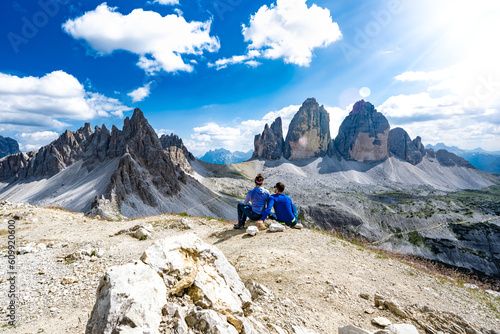 Young athletic couple enjoys scenic view on Monte Paterno and Tre Cime in the afternoon. Tre Cime, Dolomites, South Tirol, Italy, Europe.
