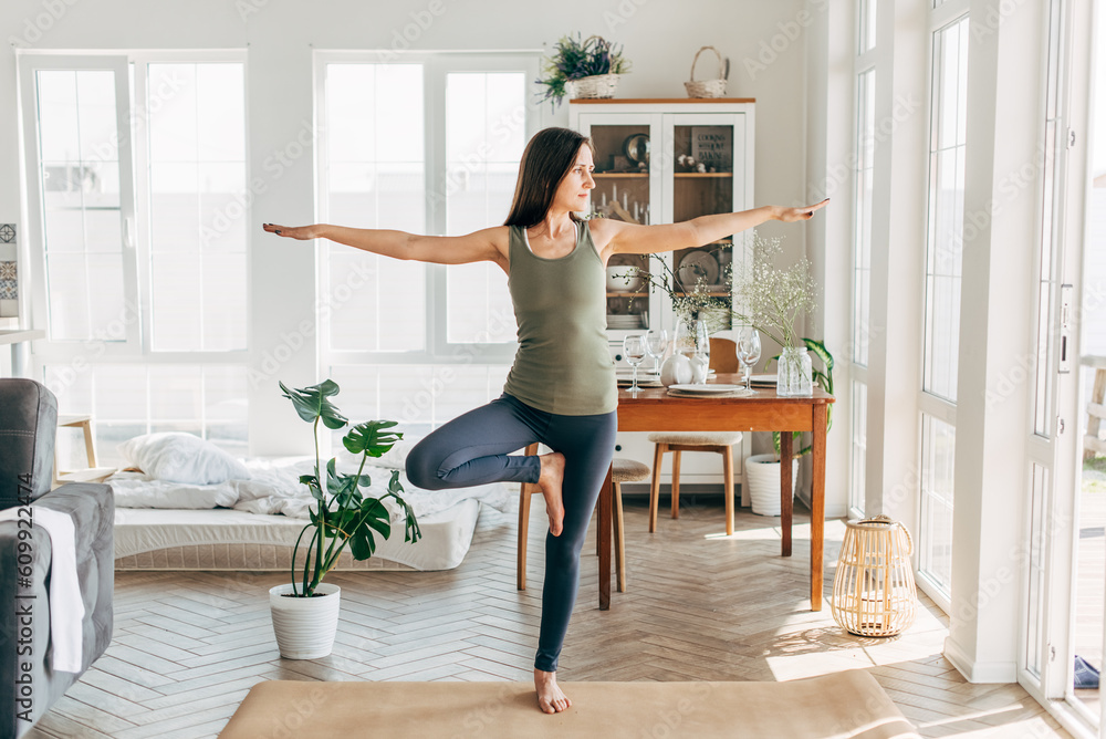 Beautiful young woman practicing yoga at home Beautiful young woman practicing yoga at home